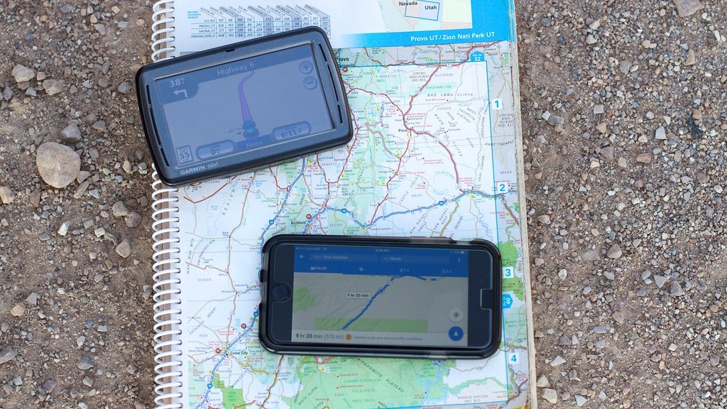 道路地図の上に置いたカーナビとスマートフォン