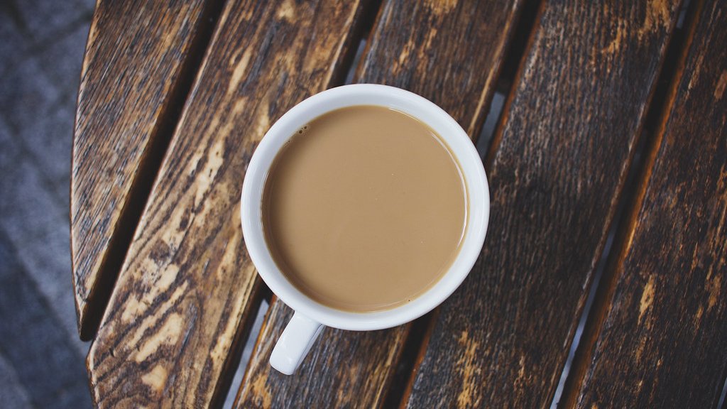 木のテーブルに置かれたコーヒーカップ