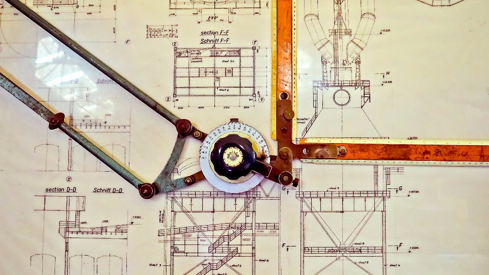 設計図の上に置かれた製図の道具