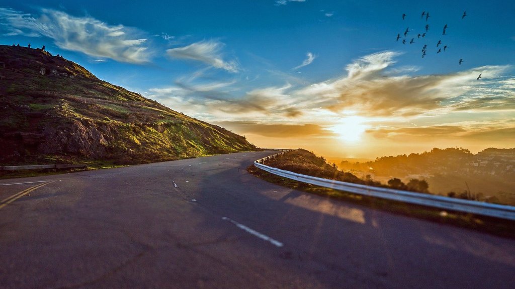 夕日に向かって山あいを伸びる道路